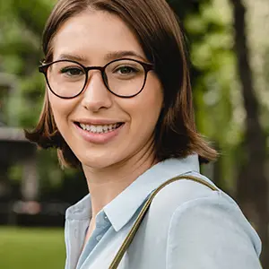 Smiling woman wearing round dark-framed glasses