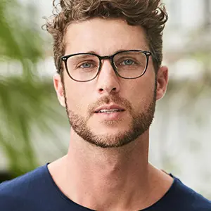 Smiling bearded man wearing dark rectangular glasses