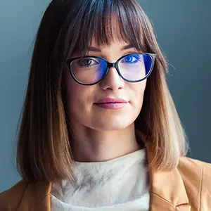 Woman with a straight brown bob wearing blue-tinted cat-eye glasses